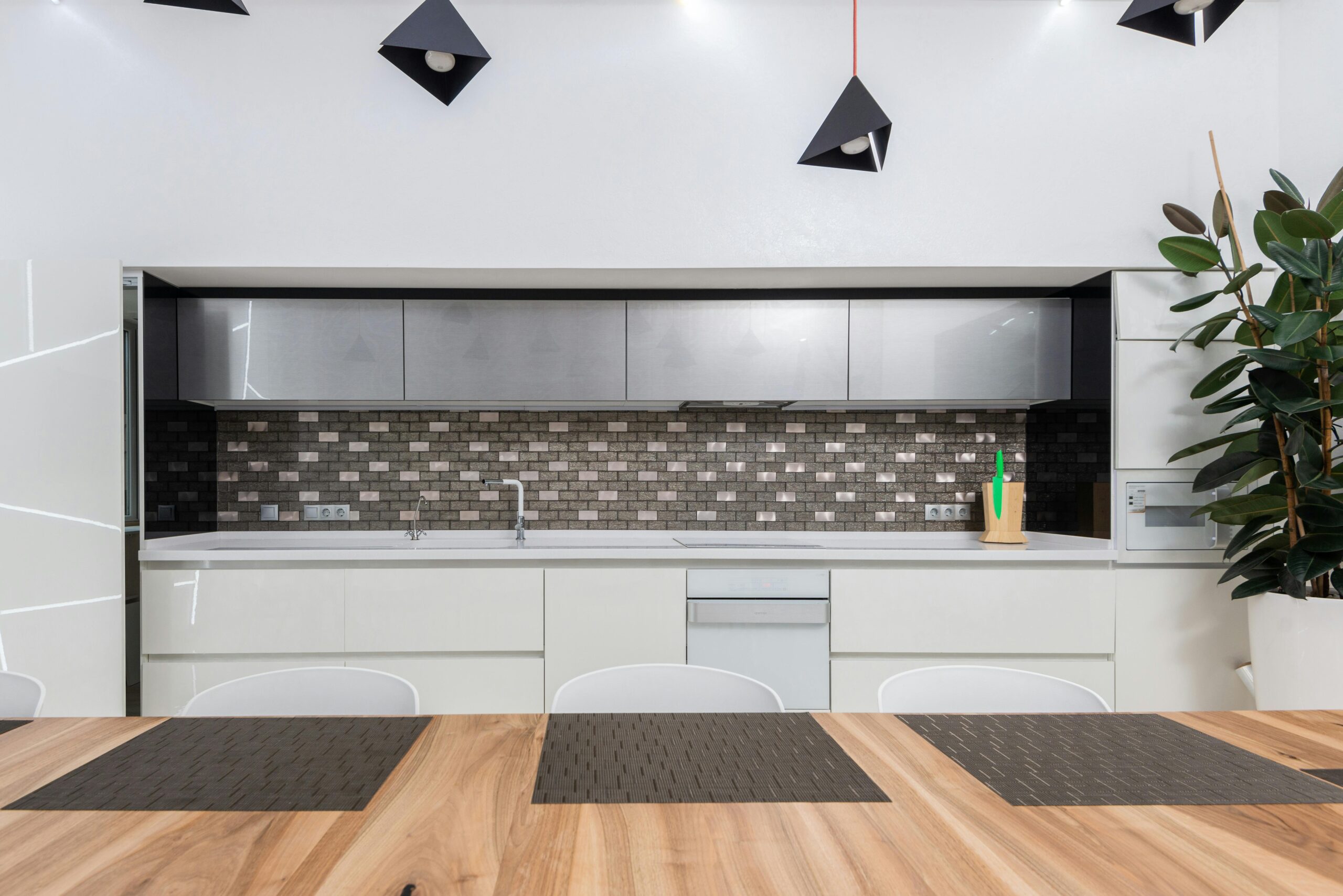 Modern minimalist kitchen featuring a grey textured peel and stick backsplash, white cabinetry, and warm wood dining table, illustrating renter-friendly quiet luxury decor.