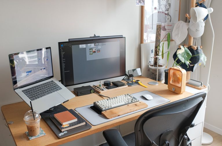 cute wallpapers displayed on laptop and monitor in a cozy aesthetic workspace