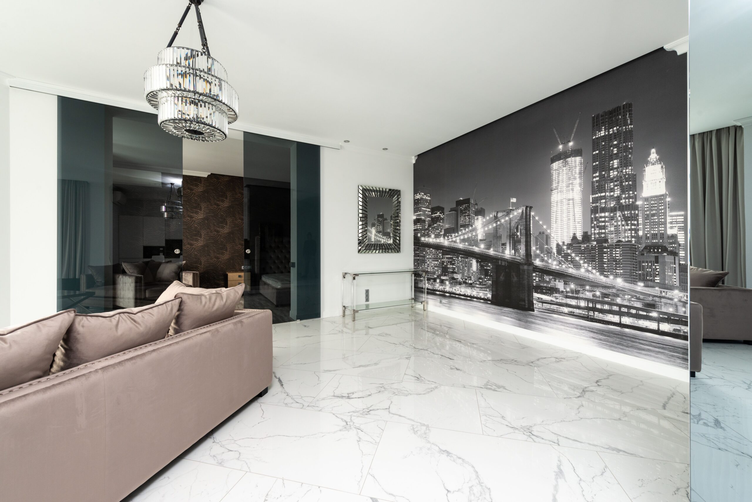 Interior of one of NYC's pet friendly apartments for rent, with white marble floors, a stylish sofa, and a black-and-white skyline mural.