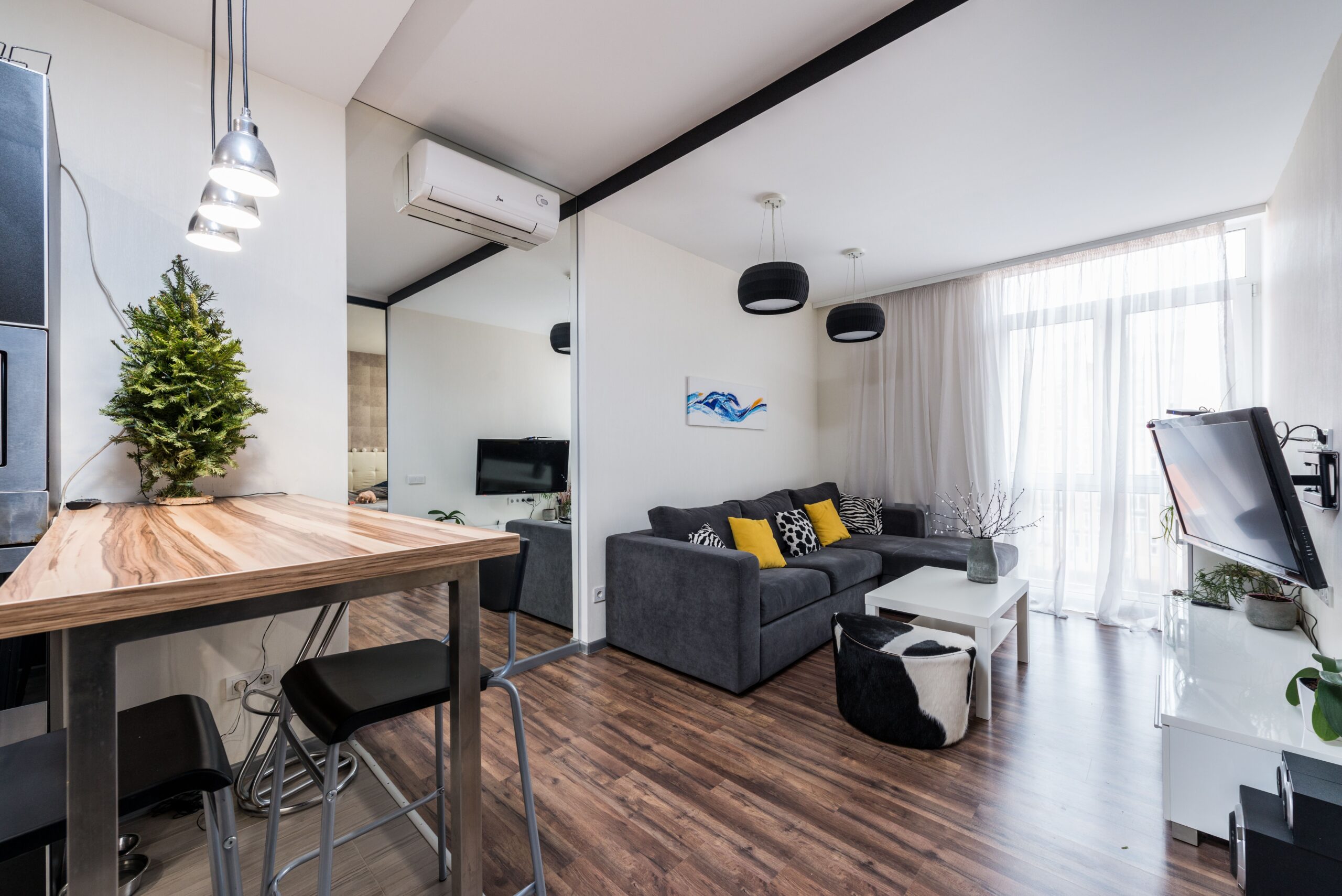 Small rental apartment living room with a sage green feature wall in renter friendly wallpaper