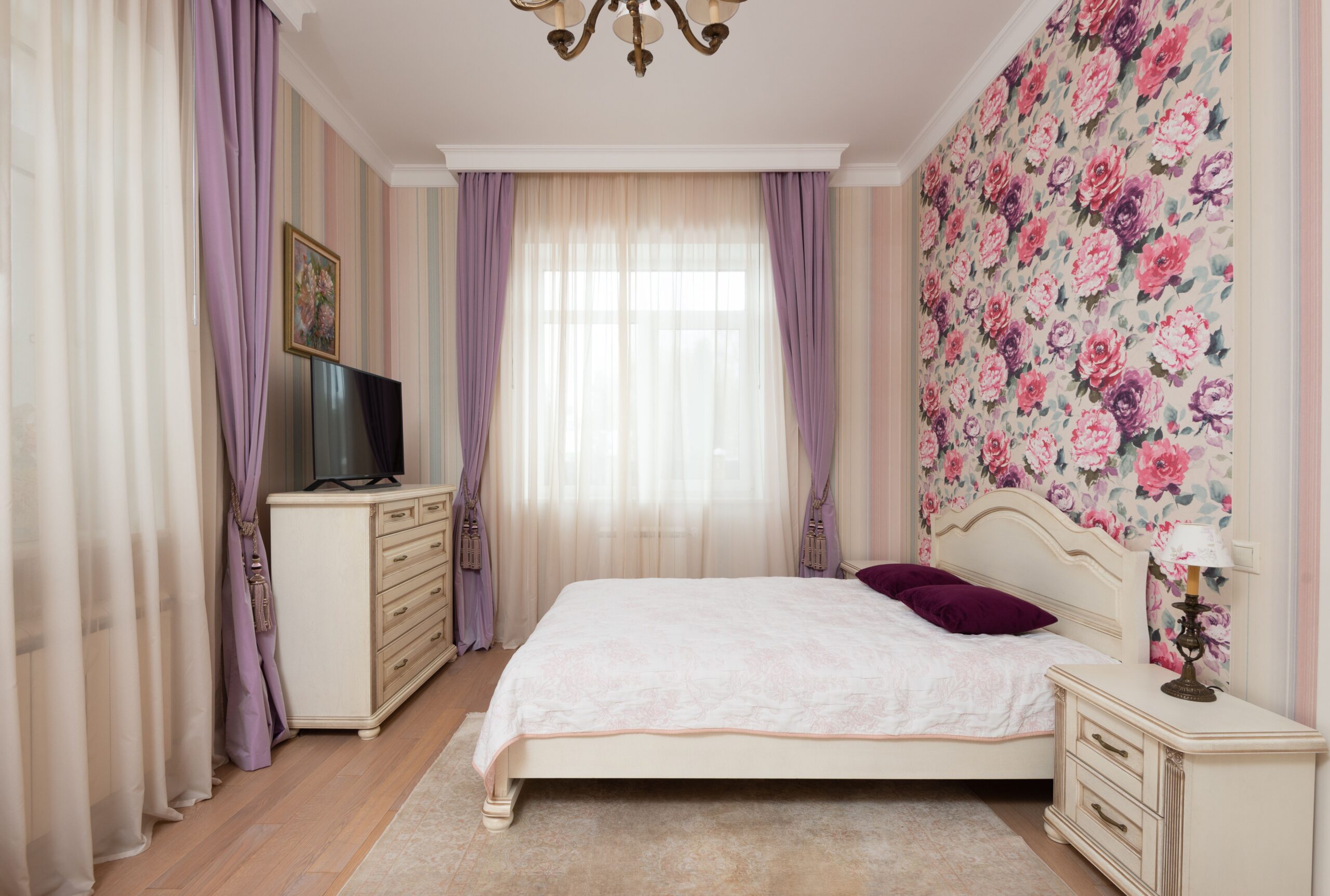 Hand smoothing peel and stick wallpaper onto a wall, an example of renter friendly wallpaper
