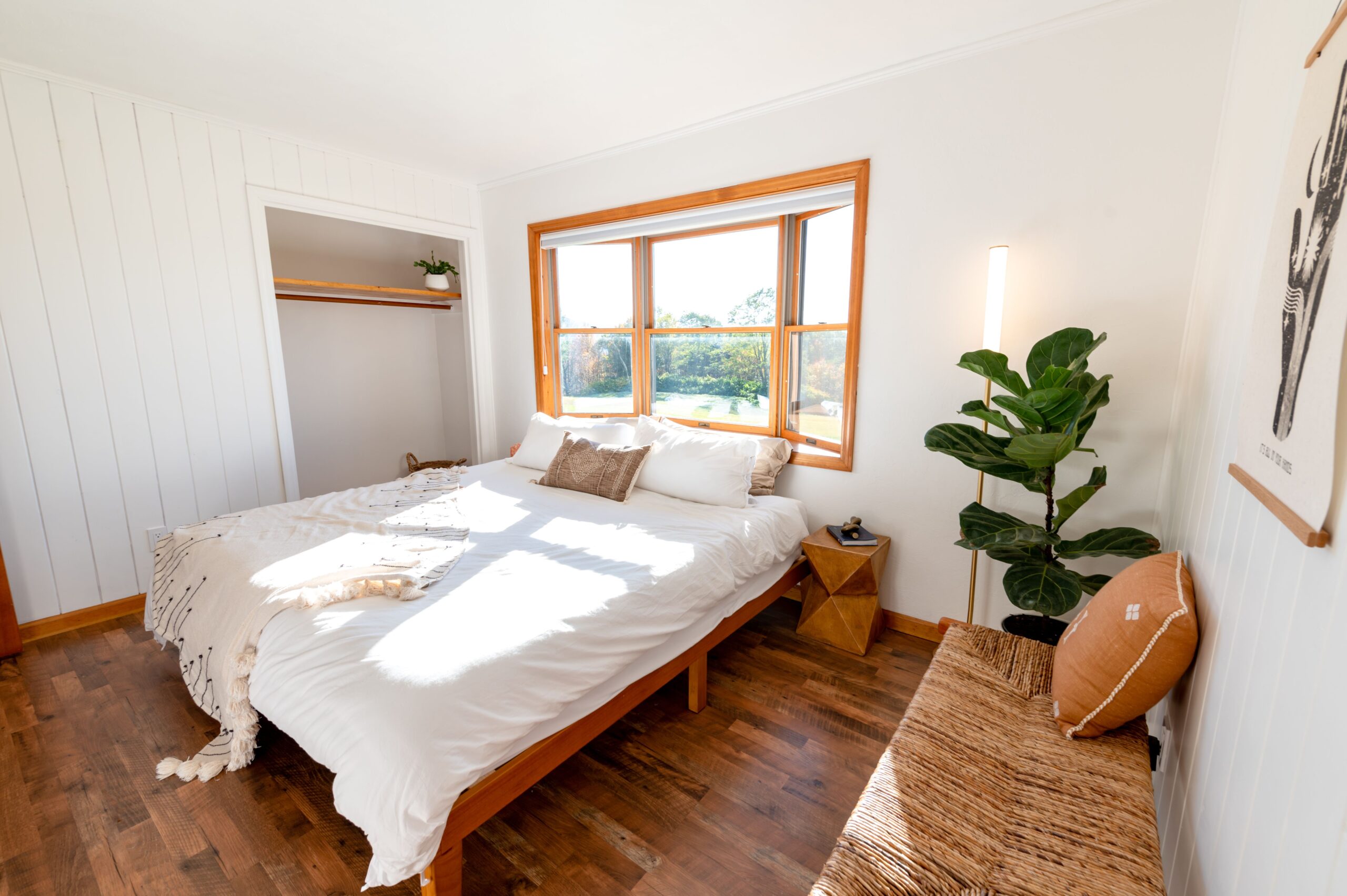 Feng shui bed placement fix with the bed angled away from the door and a low bench at the foot of the bed