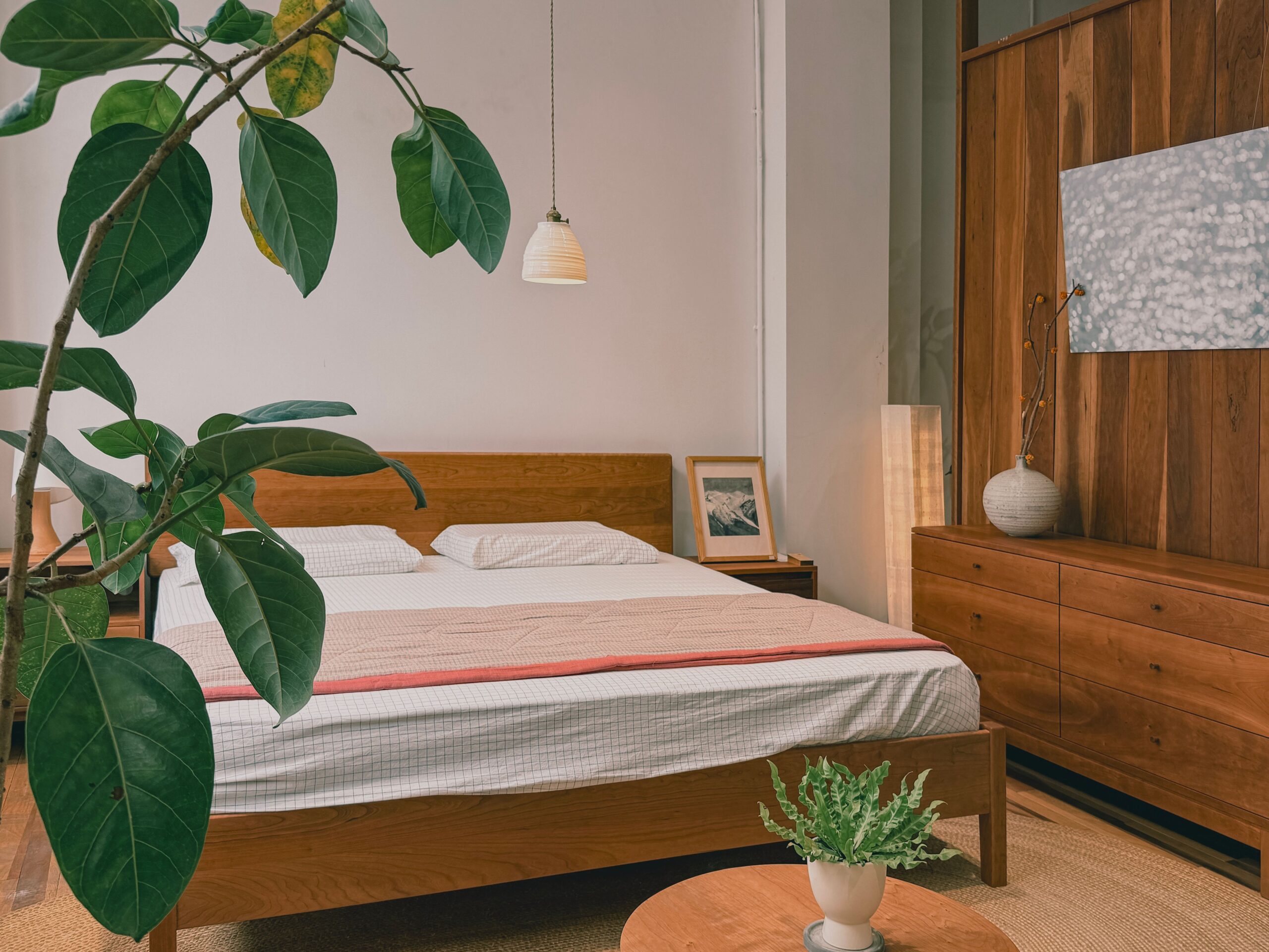 Feng shui bed placement in a small bedroom with the bed along the long wall, a slim nightstand, and an open walkway